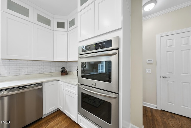 704 Walcott Way, Cary, NC 27519 - kitchen with stainless steel appliances, ornamental molding, tasteful backsplash, light stone counters, and dark wood-type flooring