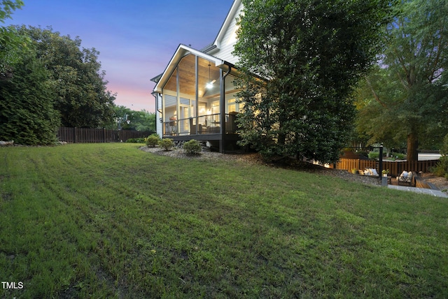 704 Walcott Way, Cary, NC 27519 - yard at dusk featuring a sunroom and a deck