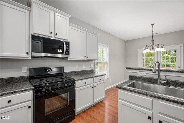 404 Straywhite Ave, Apex, NC 27539 - kitchen with stainless steel microwave, black gas stove, a sink, and dark countertops