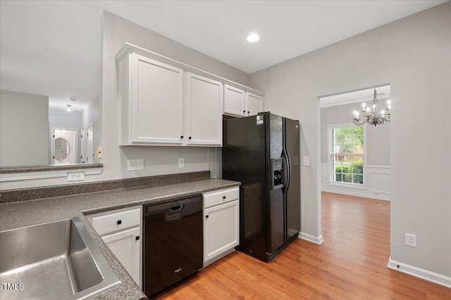 404 Straywhite Ave, Apex, NC 27539 - kitchen featuring black appliances, white cabinets, light wood finished floors, a chandelier, and a sink