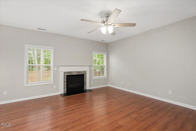 404 Straywhite Ave, Apex, NC 27539 - unfurnished living room featuring a stone fireplace, wood finished floors, baseboards, and a ceiling fan