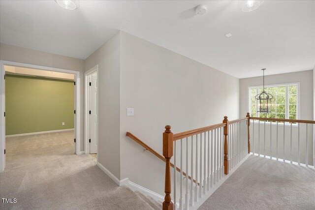 404 Straywhite Ave, Apex, NC 27539 - corridor featuring an upstairs landing, carpet flooring, baseboards, and a chandelier