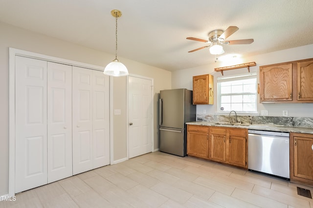 96 Landmark Dr, Angier, NC 27501 - kitchen featuring appliances with stainless steel finishes, a sink, ceiling fan, pendant lighting, and brown cabinetry
