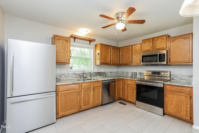 96 Landmark Dr, Angier, NC 27501 - kitchen featuring stainless steel appliances, a sink, brown cabinets, and a ceiling fan