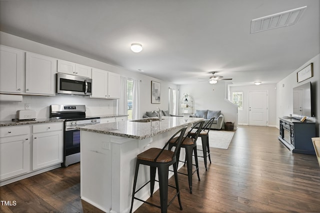 124 Teagarden Ct, Sanford, NC 27332 - kitchen with stainless steel appliances, a sink, light stone countertops, a breakfast bar, and ceiling fan