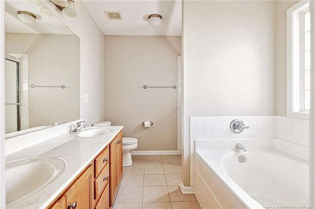 1414 Seabiscuit Dr, Parkton, NC 28371 - bathroom featuring tile patterned floors, a garden tub, double vanity, toilet, and baseboards