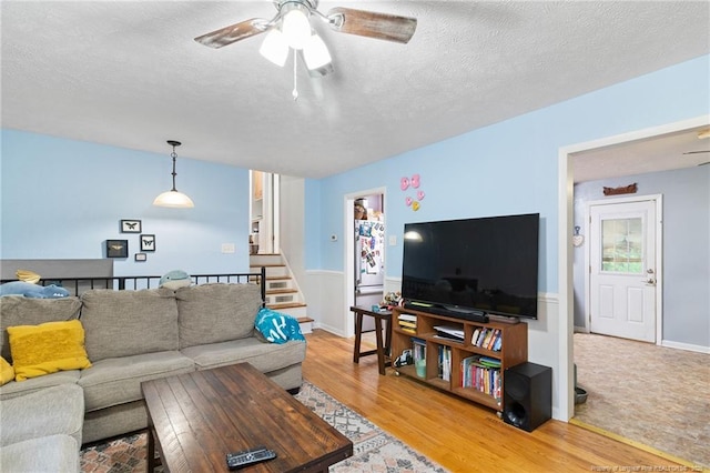 830 Edenwood Dr, Fayetteville, NC 28303 - living room featuring a ceiling fan, light wood-style floors, a textured ceiling, stairway, and a wainscoted wall