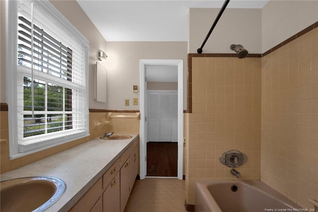 500 Cecil St, Fayetteville, NC 28312 - bathroom with tile walls, double vanity,  shower combination, a wainscoted wall, and tile patterned floors
