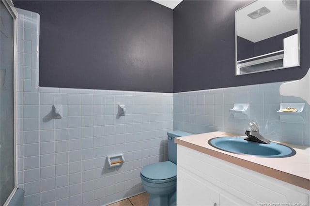 500 Cecil St, Fayetteville, NC 28312 - full bath featuring vanity, tile walls, toilet, tile patterned flooring, and wainscoting