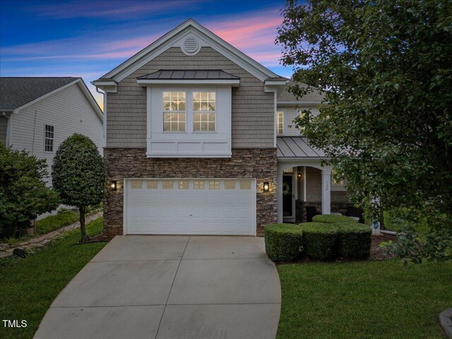 132 Ryder Cup Cir, Raleigh, NC 27603 - view of front of home featuring a standing seam roof, stone siding, an attached garage, a metal roof, and a lawn