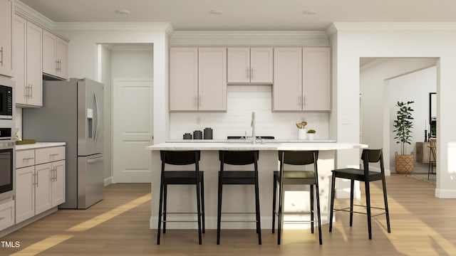 945 Cassa Clubhouse Way, Knightdale, NC 27545 - kitchen featuring appliances with stainless steel finishes, a sink, light wood finished floors, decorative backsplash, and a breakfast bar