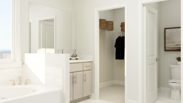 945 Cassa Clubhouse Way, Knightdale, NC 27545 - bathroom with toilet, a bath, vanity, a spacious closet, and baseboards