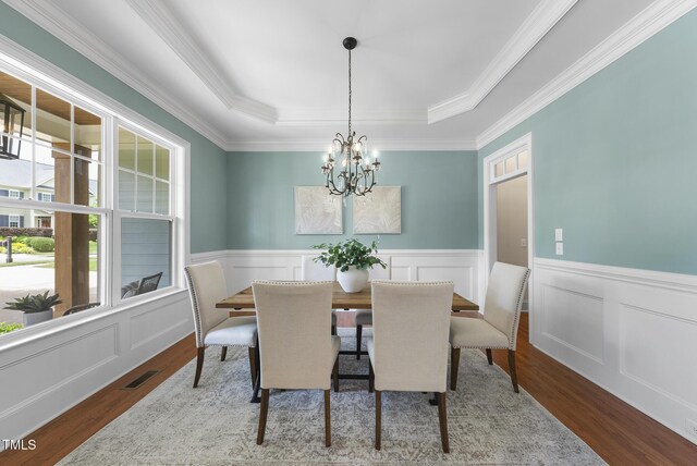 106 Painted Turtle Ln, Cary, NC 27519 - dining room featuring a raised ceiling, a chandelier, wood finished floors, wainscoting, and ornamental molding