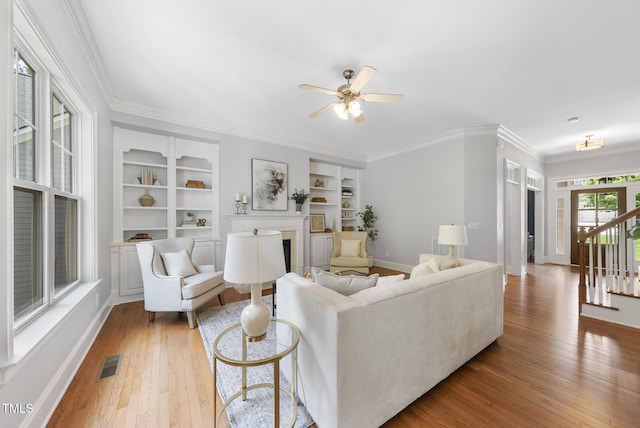106 Painted Turtle Ln, Cary, NC 27519 - living area featuring light wood-type flooring, baseboards, built in shelves, ceiling fan, and a fireplace