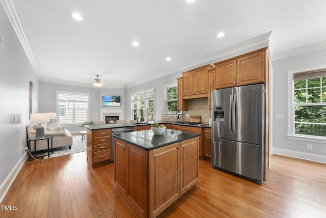 106 Painted Turtle Ln, Cary, NC 27519 - kitchen with stainless steel appliances, baseboards, a center island, light wood-style flooring, and crown molding