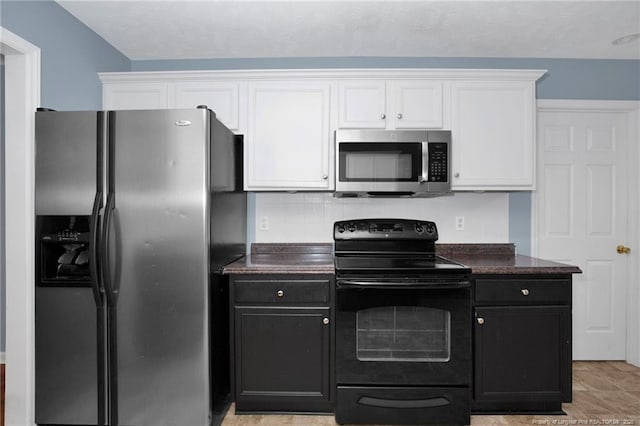 188 Fallingleaf Dr, Raeford, NC 28376 - kitchen with stainless steel appliances, white cabinetry, backsplash, and dark cabinets