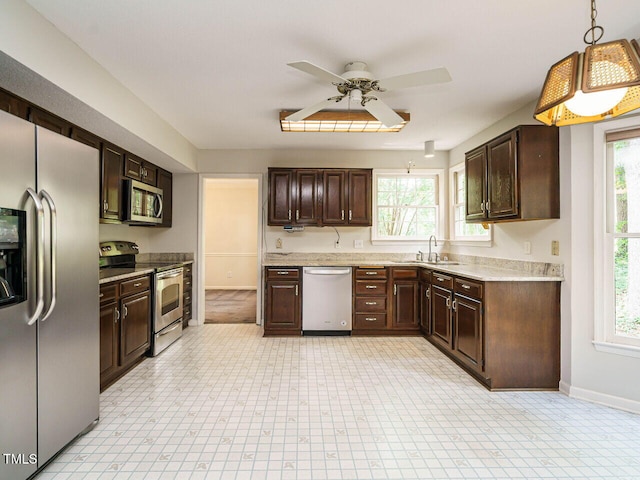 108 S Drawbridge Ln, Cary, NC 27513 - kitchen with appliances with stainless steel finishes, dark brown cabinetry, a ceiling fan, and light countertops
