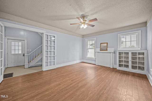 421 E Morehead St, Burlington, NC 27215 - unfurnished living room with wood finished floors, ceiling fan, a textured ceiling, stairs, and baseboards