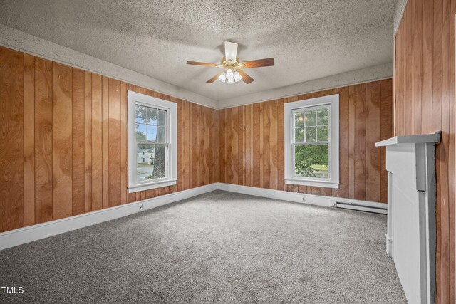 421 E Morehead St, Burlington, NC 27215 - empty room with a ceiling fan, carpet, wood walls, a baseboard radiator, and a textured ceiling