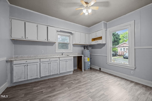 421 E Morehead St, Burlington, NC 27215 - kitchen with water heater, wood finished floors, crown molding, light countertops, and a textured ceiling