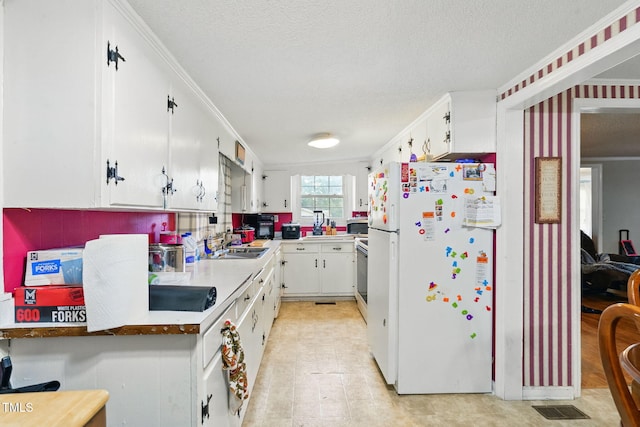 480 Five Bridge Rd, Clinton, NC 28328 - kitchen featuring freestanding refrigerator, a textured ceiling, white cabinetry, ornamental molding, and light floors