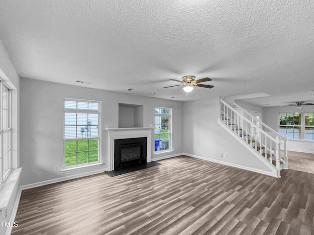 1216 Briarwood Dr, Mebane, NC 27302 - unfurnished living room featuring ceiling fan, stairs, wood finished floors, baseboards, and a textured ceiling