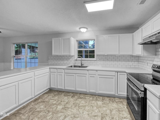 1216 Briarwood Dr, Mebane, NC 27302 - kitchen featuring stainless steel electric range, a sink, under cabinet range hood, white cabinetry, and light countertops