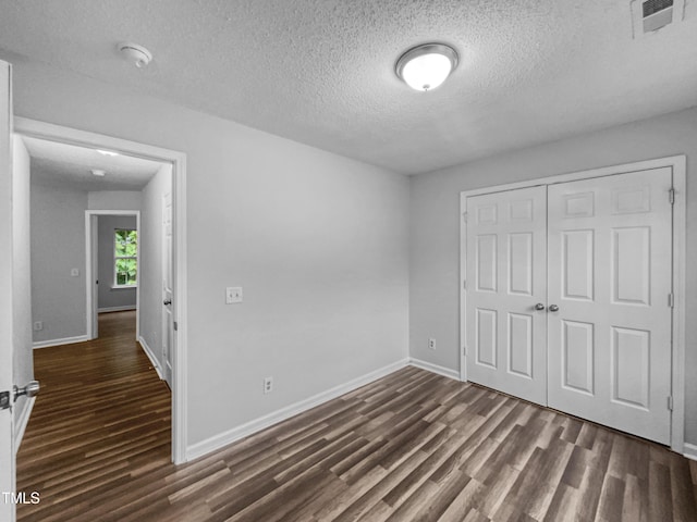 1216 Briarwood Dr, Mebane, NC 27302 - unfurnished bedroom with dark wood-style flooring, a textured ceiling, a closet, and baseboards