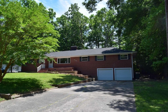 515 Wildwood Dr, Durham, NC 27712 - single story home featuring asphalt driveway, a garage, brick siding, a front lawn, and a chimney