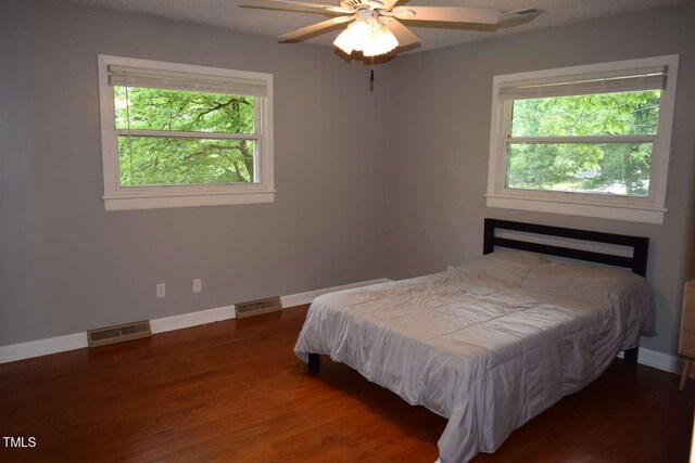 515 Wildwood Dr, Durham, NC 27712 - bedroom featuring multiple windows, wood finished floors, baseboards, and a ceiling fan