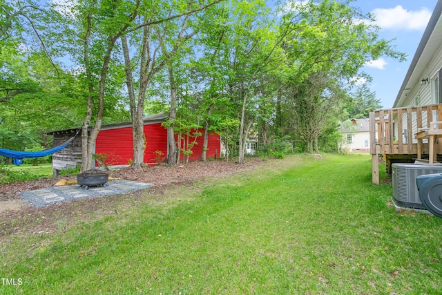 101 Hazy Ln, Thomasville, NC 27360 - view of grassy yard featuring central AC unit, a fire pit, a deck, and an outdoor structure