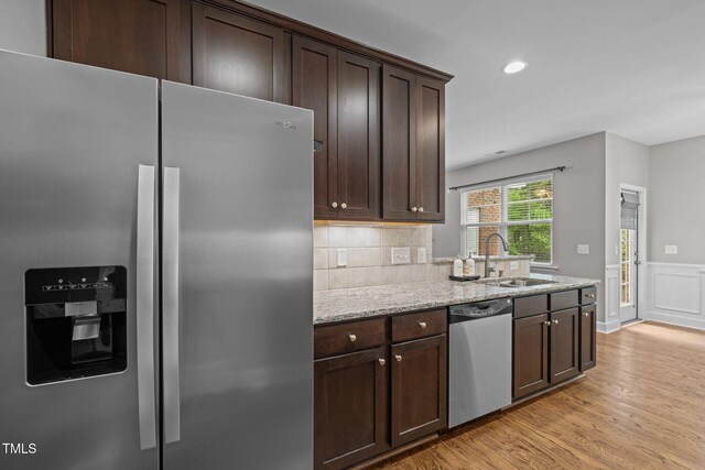 238 Langford Valley Way, Cary, NC 27513 - kitchen featuring appliances with stainless steel finishes, a sink, dark brown cabinets, light wood finished floors, and wainscoting