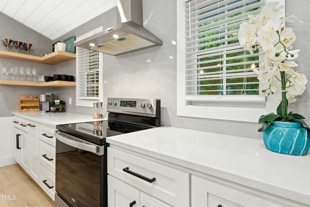 117 Bertie Dr, Raleigh, NC 27610 - kitchen featuring electric stove, extractor fan, backsplash, white cabinets, and light wood finished floors
