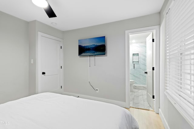 117 Bertie Dr, Raleigh, NC 27610 - bedroom with ensuite bathroom, baseboards, light marble finish flooring, and ceiling fan