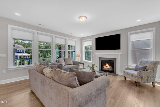 109 Crested Coral Dr, Holly Springs, NC 27540 - living room with a fireplace with flush hearth, light wood finished floors, baseboards, and recessed lighting
