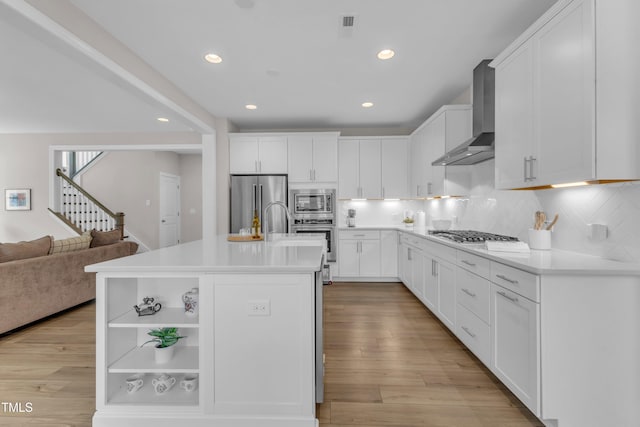 109 Crested Coral Dr, Holly Springs, NC 27540 - kitchen with wall chimney range hood, appliances with stainless steel finishes, recessed lighting, tasteful backsplash, and white cabinets