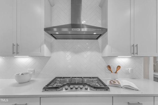 109 Crested Coral Dr, Holly Springs, NC 27540 - kitchen with wall chimney exhaust hood, stainless steel gas cooktop, light countertops, white cabinets, and decorative backsplash