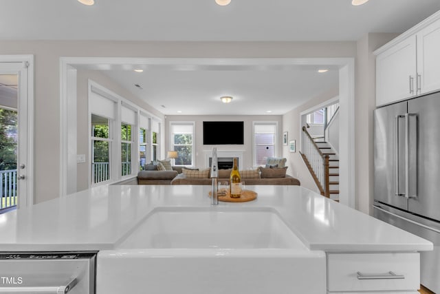 109 Crested Coral Dr, Holly Springs, NC 27540 - kitchen featuring appliances with stainless steel finishes, open floor plan, a sink, light countertops, and plenty of natural light