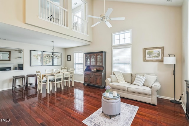 6 Newgate Ct, Durham, NC 27713 - living room featuring a towering ceiling, ceiling fan, baseboards, dark wood-style flooring, and a chandelier