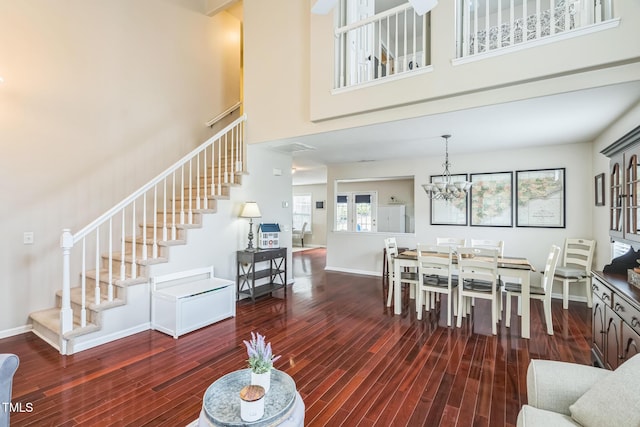 6 Newgate Ct, Durham, NC 27713 - living room featuring stairs, wood finished floors, a towering ceiling, a chandelier, and baseboards