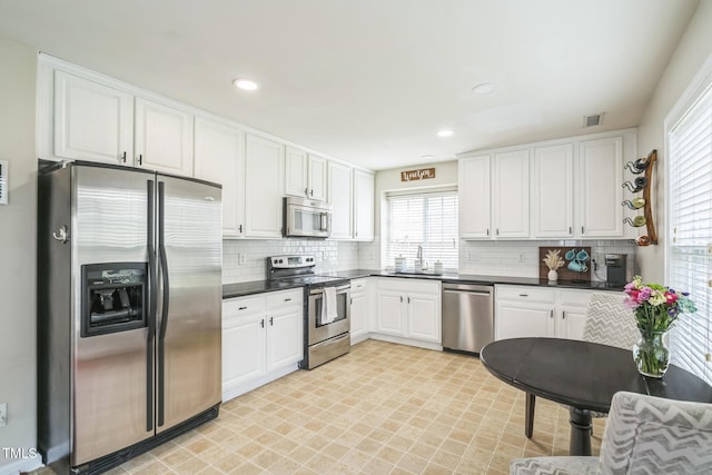 6 Newgate Ct, Durham, NC 27713 - kitchen with stainless steel appliances, a sink, dark countertops, white cabinetry, and recessed lighting