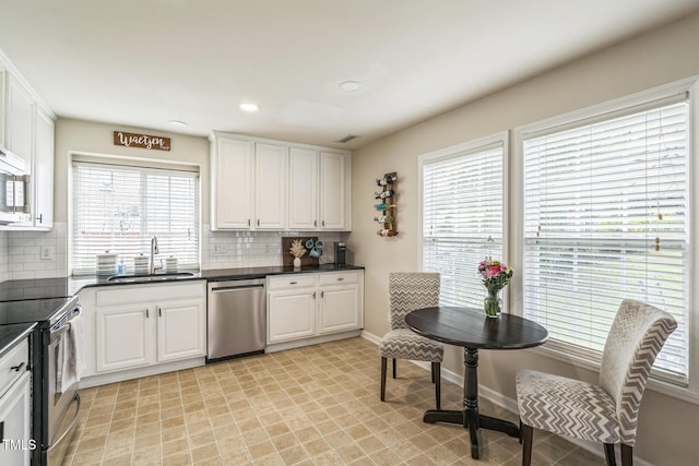 6 Newgate Ct, Durham, NC 27713 - kitchen featuring appliances with stainless steel finishes, a sink, dark countertops, tasteful backsplash, and recessed lighting