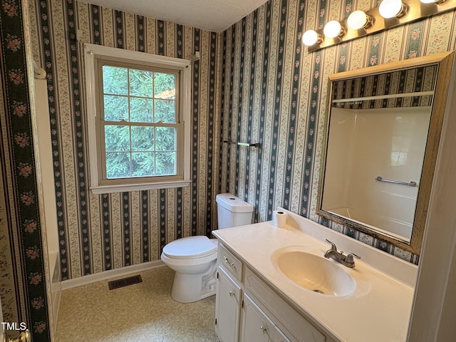 1942 Brier Ln, Graham, NC 27253 - bathroom featuring vanity, wallpapered walls, toilet, and baseboards