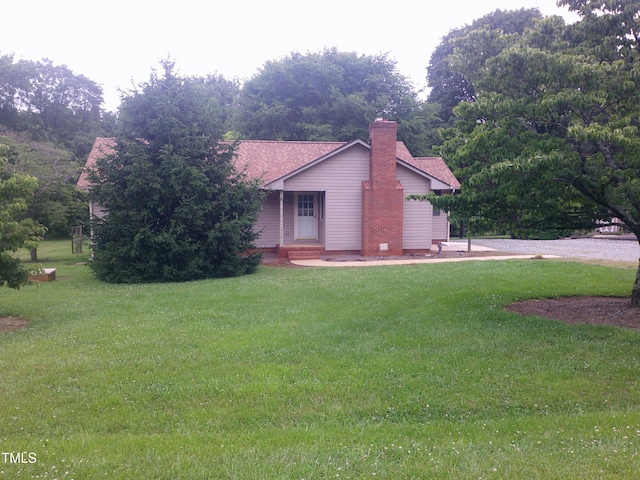 1942 Brier Ln, Graham, NC 27253 - view of front facade featuring a front yard, a chimney, and roof with shingles