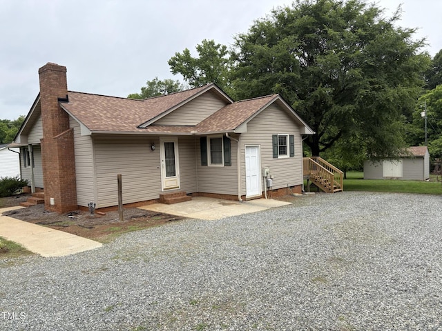 1942 Brier Ln, Graham, NC 27253 - view of front facade featuring a shingled roof, a chimney, gravel driveway, and crawl space