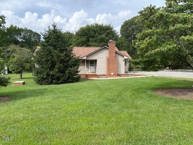 1942 Brier Ln, Graham, NC 27253 - view of property exterior featuring a lawn and a chimney