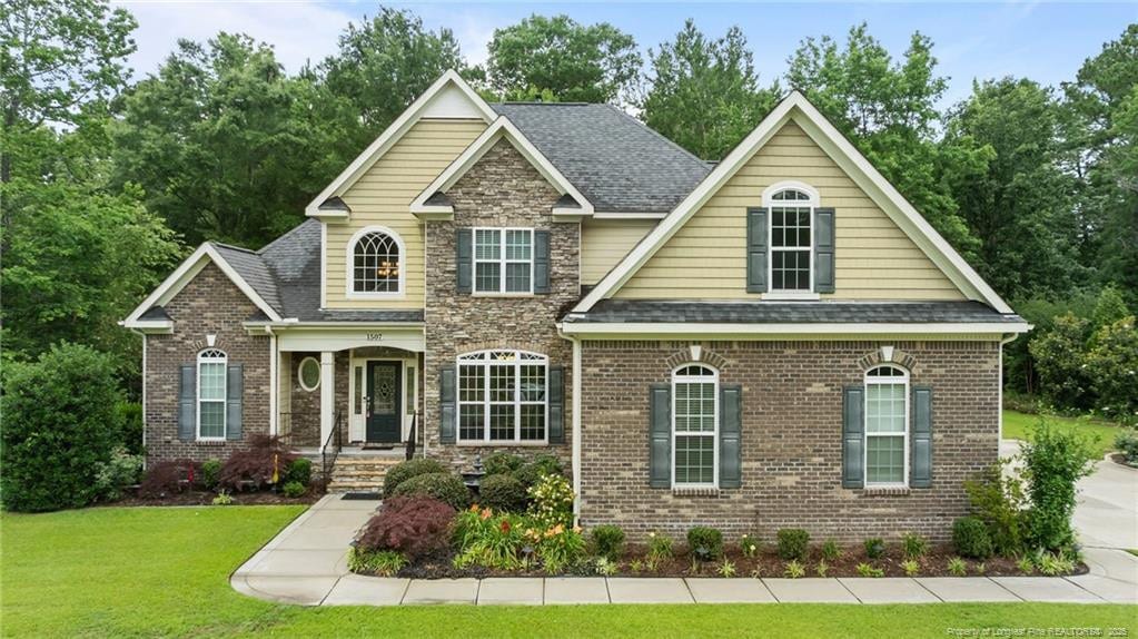 1507 Heatherly Ct, Fayetteville, NC 28312 - view of front of home featuring a front lawn, roof with shingles, and brick siding