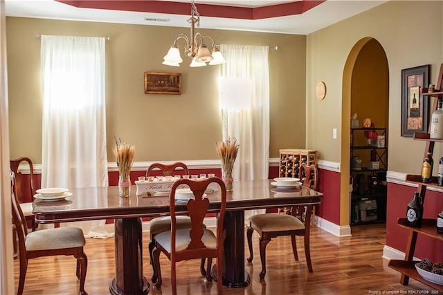 101 Birdsong Ct, Aberdeen, NC 28315 - dining room featuring arched walkways, wood finished floors, plenty of natural light, a chandelier, and wainscoting