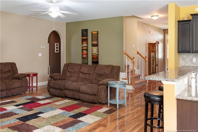 101 Birdsong Ct, Aberdeen, NC 28315 - living room with light wood-style flooring, a ceiling fan, arched walkways, baseboards, and stairs