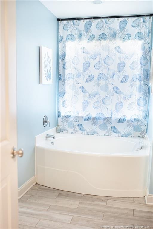 101 Birdsong Ct, Aberdeen, NC 28315 - bathroom featuring a bathtub, wood finish floors, baseboards, and curtained shower